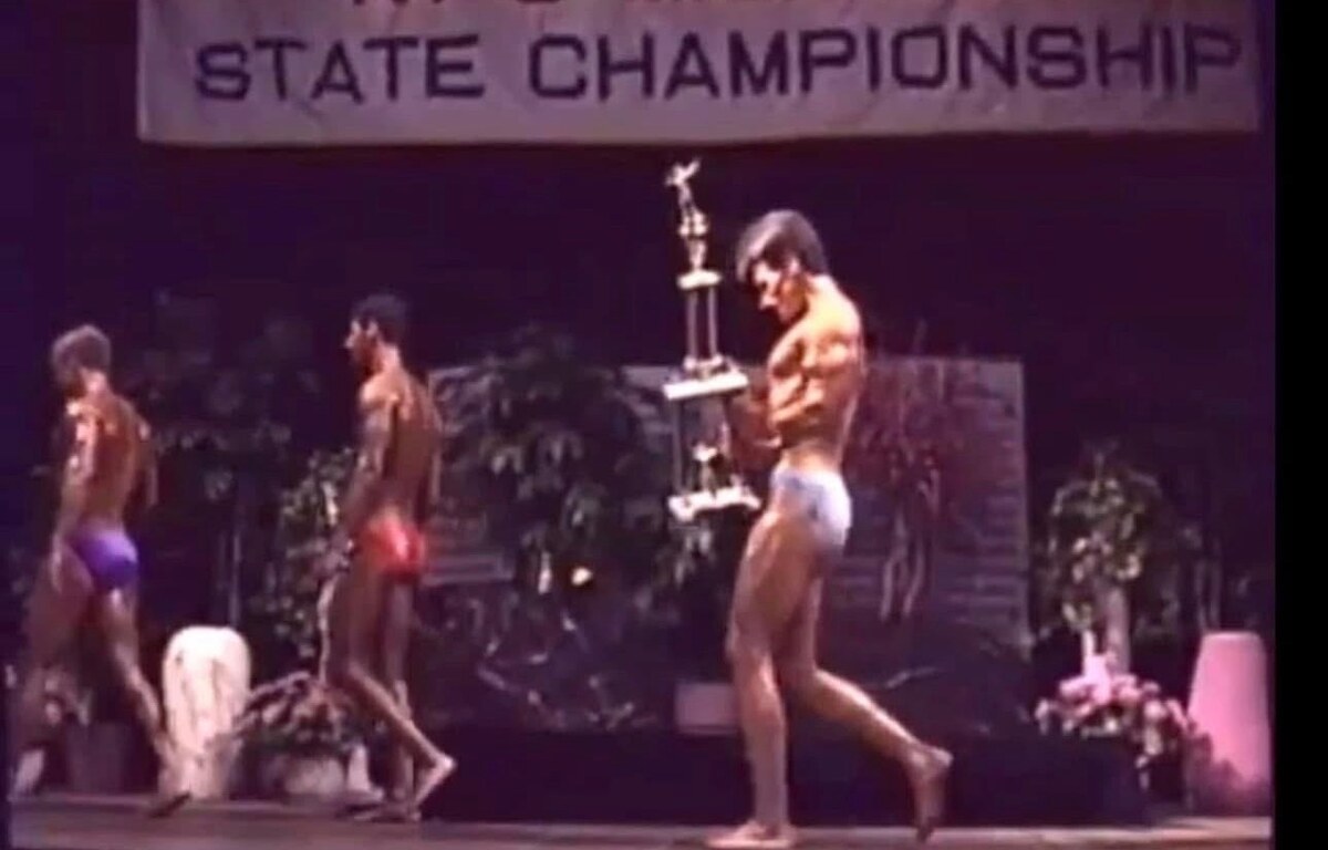 Dr. David Waring competing at a state bodybuilding championship — the NPC Mr. Michigan champion and 'Gym Chiropractor' behind Health Link Chiropractic Clinic in Sterling Heights, Michigan